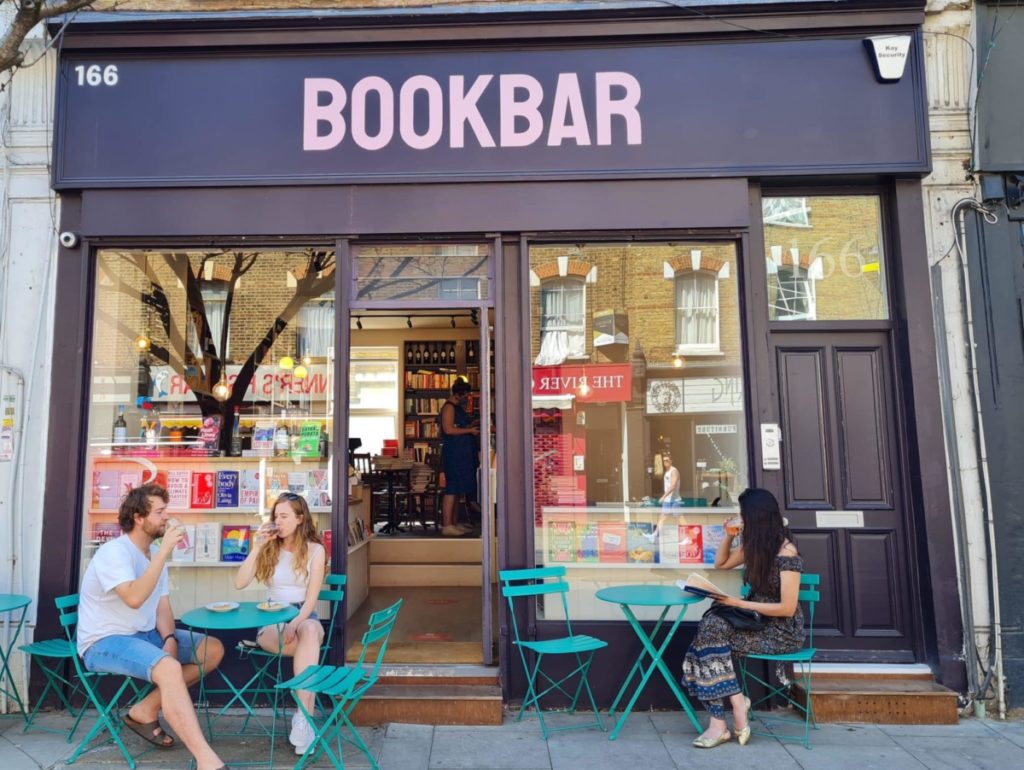 people sat at tables enjoying books and wine outside bookbar