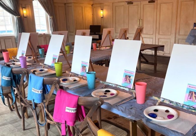 Some paints at canvases set up for a painting class at Brush and Bubbles