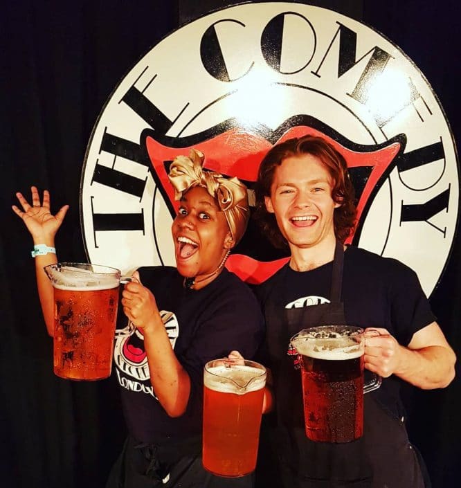 Two people serving drinks at The Comedy Store in London, one of the best London comedy clubs