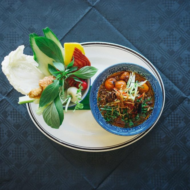 A plate of Nham Prik Ong', a smoky pork belly, fermented soya bean and tomato relish, served with seasonal British dipping vegetables, pork scratching and fresh herbs