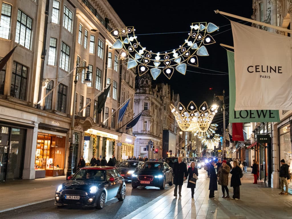the bond street christmas lights lit up at night, with revellers and cars travelling underneath