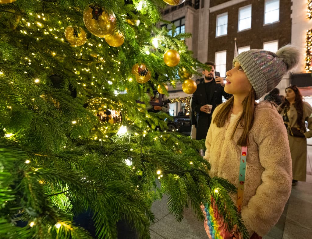 Eleanor Hirons, age 6, engages with The Ralph Lauren Giving Tree for Bond Street in support of The Royal Marsden Cancer Charity in London following its annual festive lights switch-on