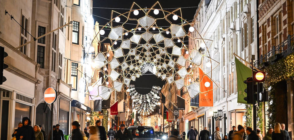 the bond street christmas lights shining down over Londoners at night