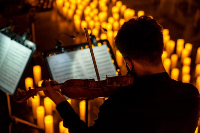 A violinist reading sheet music at a candlelight Valentine's Day concert