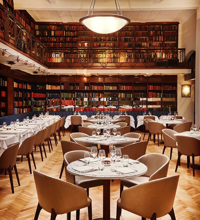 the interior of the Cinnamon Club, with an impressive wall of books circling the dining room