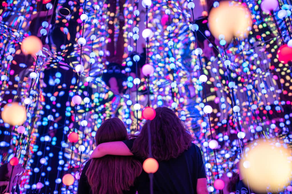two friends with their arm around each other in a colourful infinity room at Dopamine Land