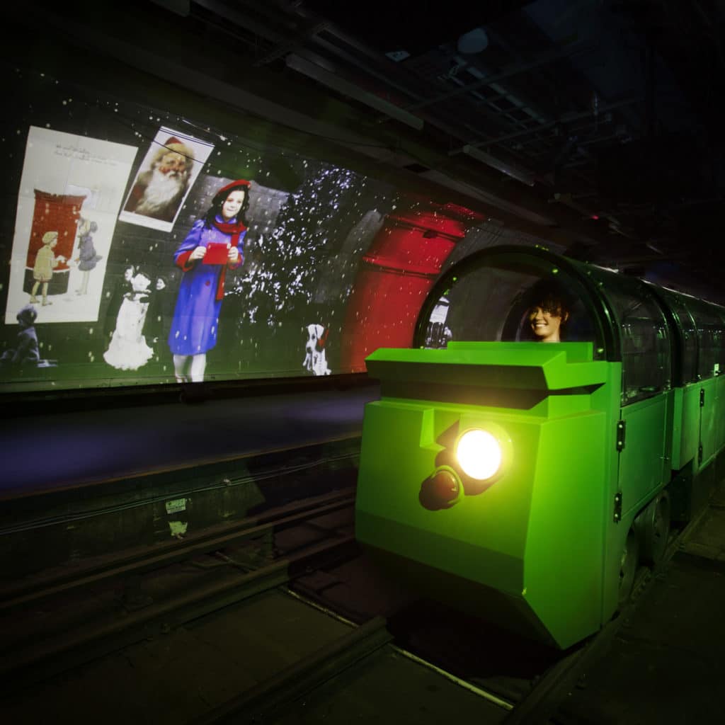 the postal museum's mail rail going past one of the festive christmas displays during its journey