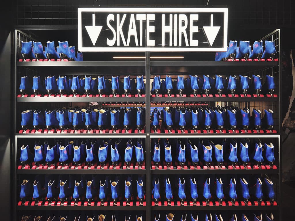a wall of blue and red skates available for rental from flipper's roller boogie palace