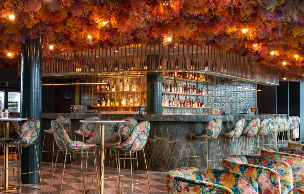 the bar at florattica, with seats scattered around it that have been upholstered with a floral fabric