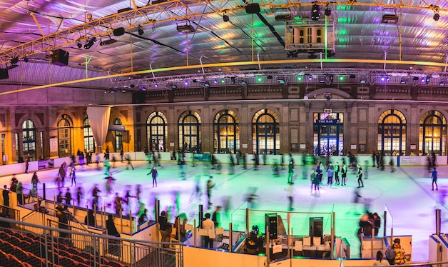 People skating across the wide swathe of ice at Alexandra Palace