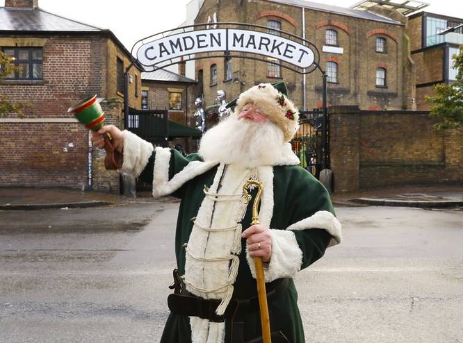 A man dressed as Santa standing outside Camden Market 
