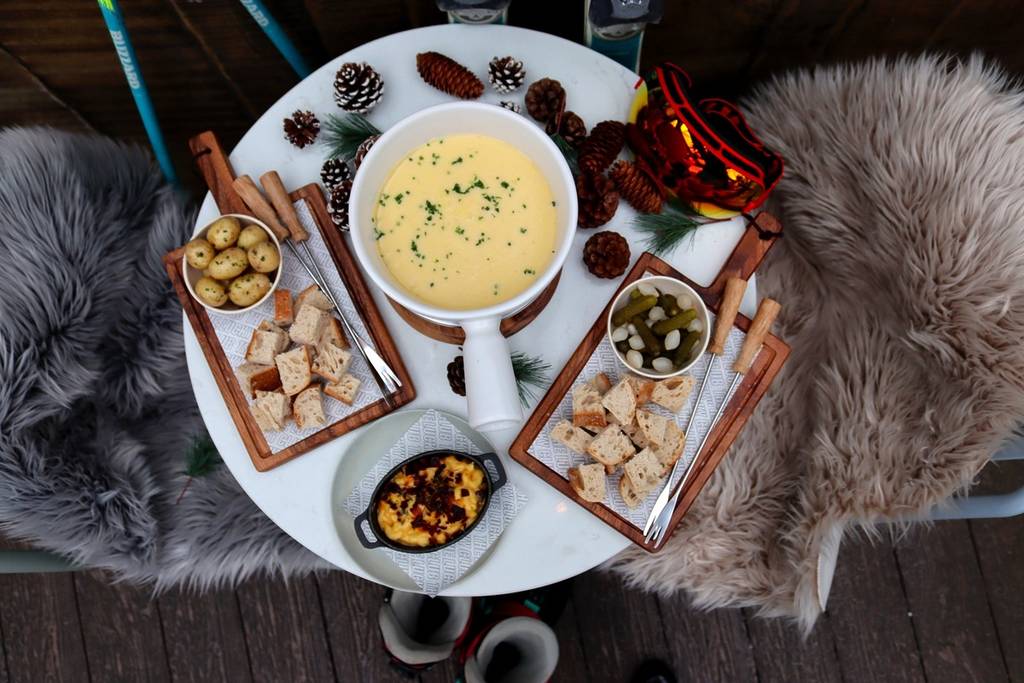 a table of food, fondue, dippers, and mac and cheese