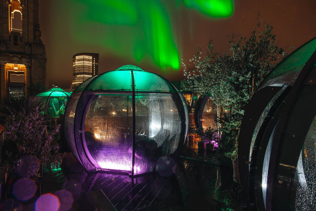 the igloos beneath the northern light projections at the aviary rooftop