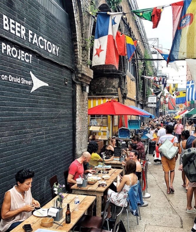 People enjoying food at Maltby Street Market – a great spot for a first date in London