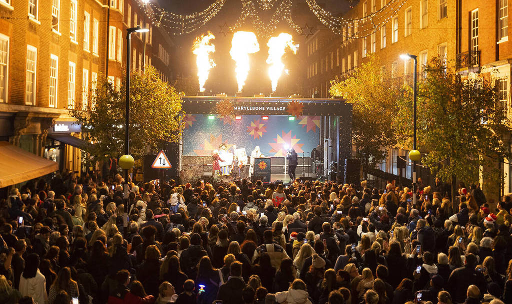the marylebone christmas lights celebration, with a crowd of people in front of the stage as the lights are switched on