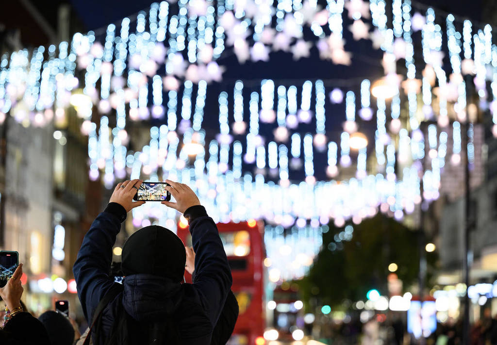 someone taking a photograph of the oxford street christmas lights