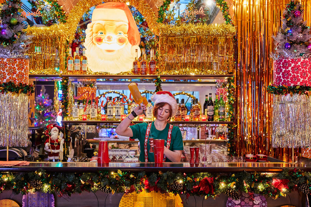 a bartender amidst the super christmassy decor at Miracle at Henrietta