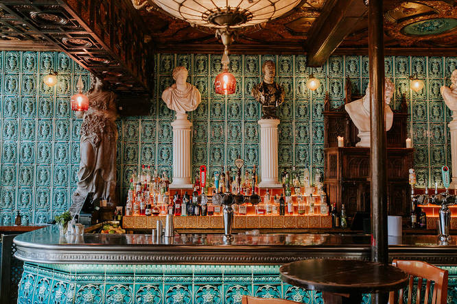 The back bar at the Old Queen's Head, with marble busts and ornate green wall details