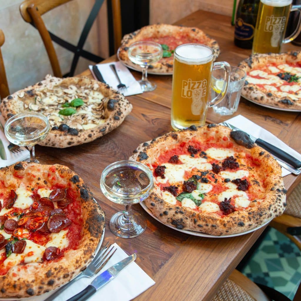 a selection of pizzas and drinks