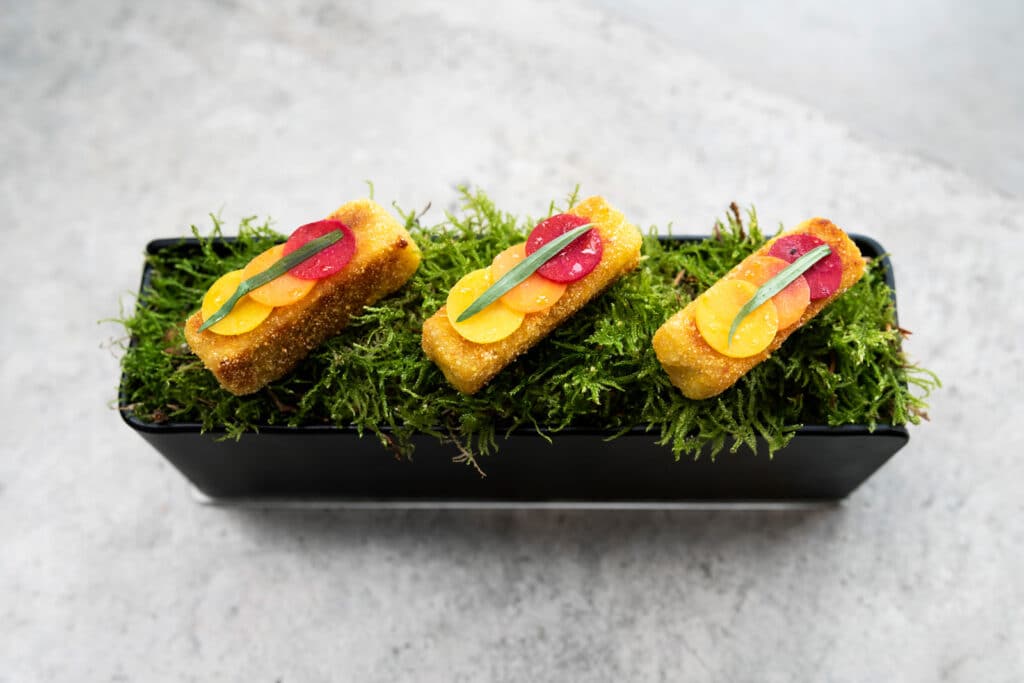 a dish from one of London's Michelin star restaurants, Story, showing three bites perched atop what looks to be a grassy flowerpot