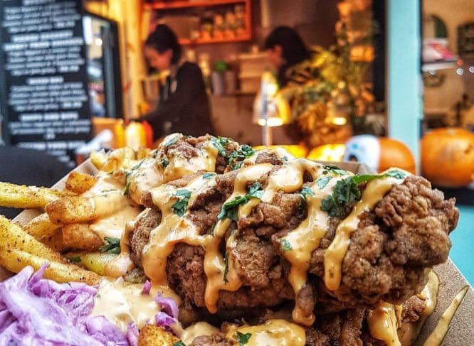 A delicious plate of street food drizzled in cheese served at Sevel Dials Market 