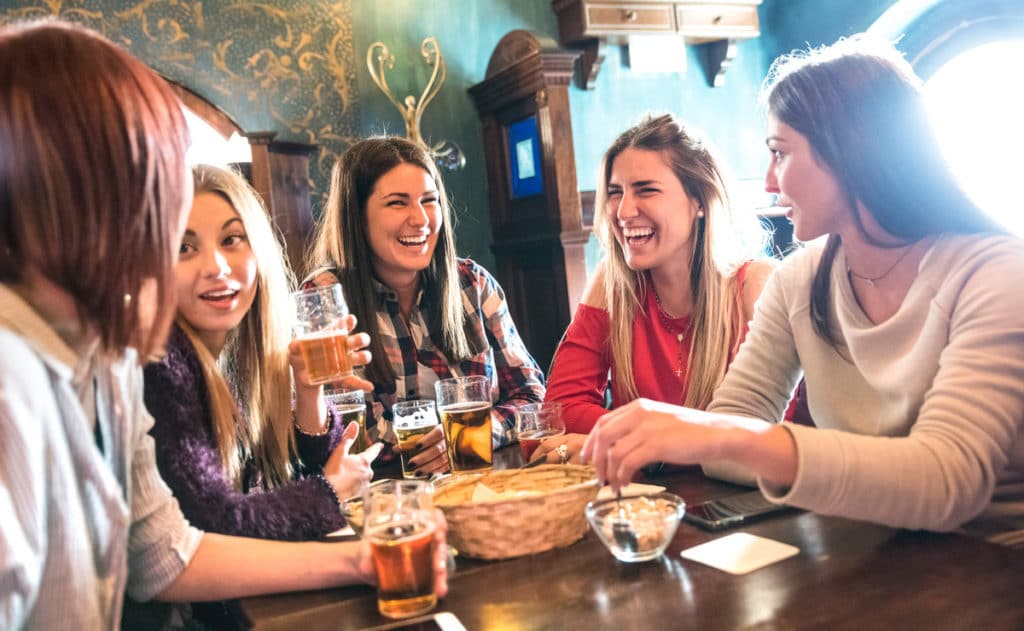 Five girls enjoying themselves over pints and snacks at one of the best pub quizzes in London