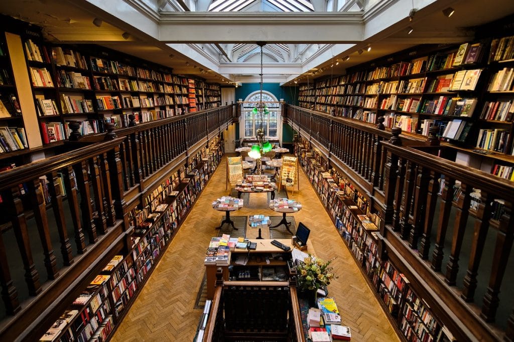 the interior of daunt books, showing two floors of shelving and books