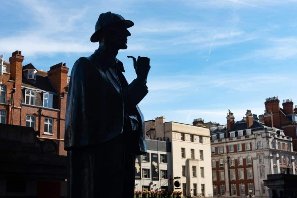 a statue of sherlock holmes in the shadow