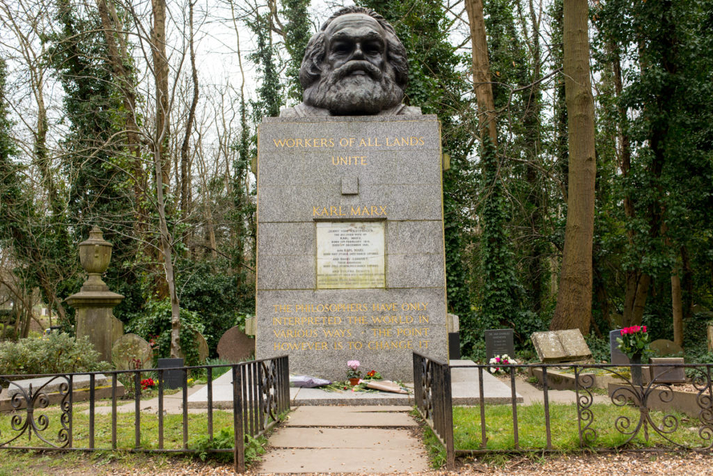 the grave of karl marx, with a large bust of his face perched atop it