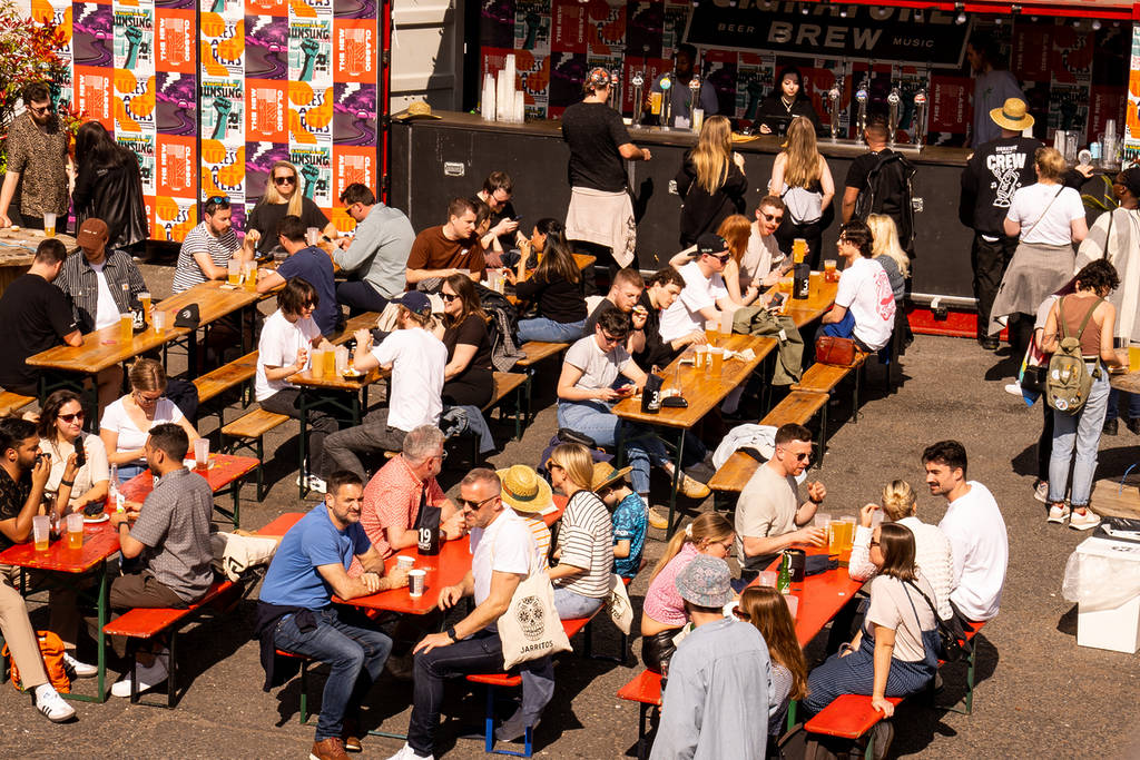 people sitting in the sunshine at signature brewery during the tacover festival