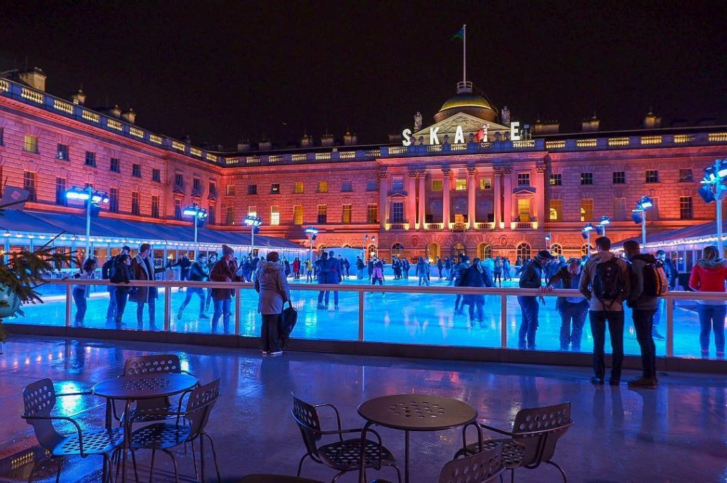 Multiple people practicing their skills on the ice skating rink at Somerset House