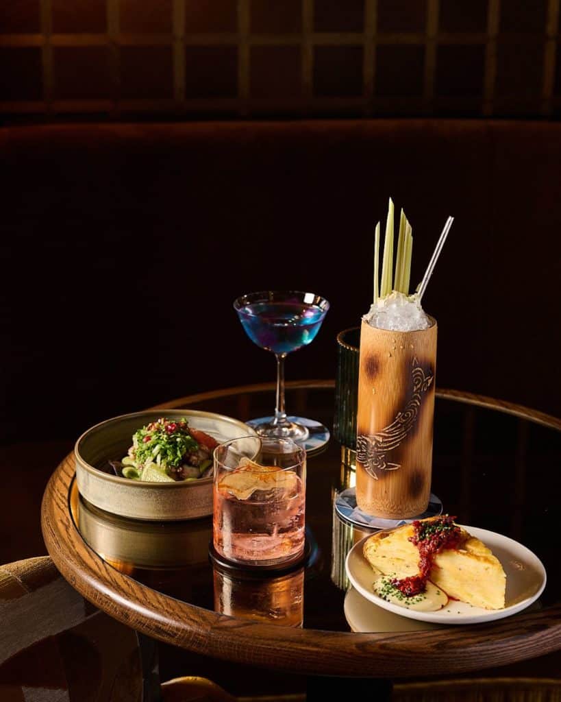 a selection of happy hour dishes and drinks from alma bar london
