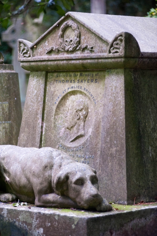 a statue of a dog perched atop a tomb