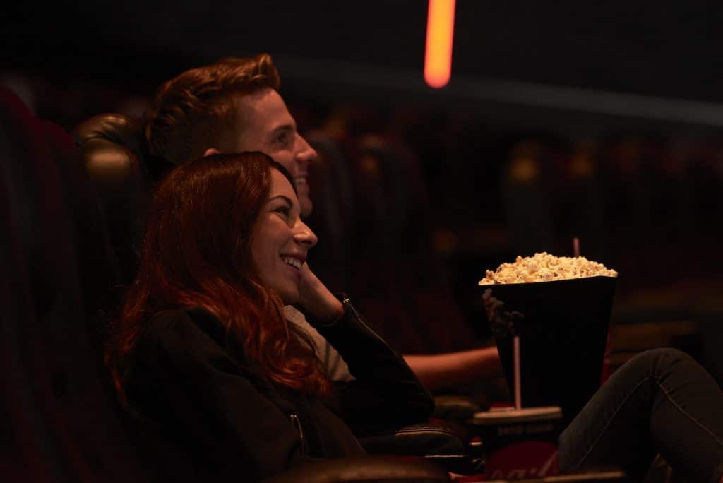 Couple in cinema eating popcorn
