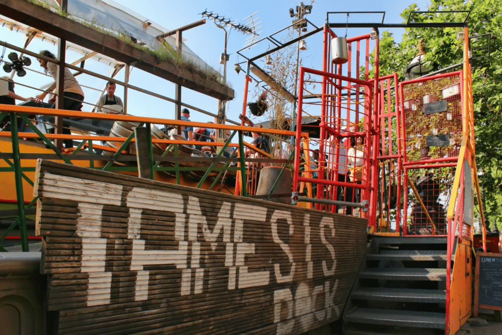 a shot of the sign reading 'Tamesis Dock' that welcomes visitors onboard as they ascend the stairs onto the floating pub