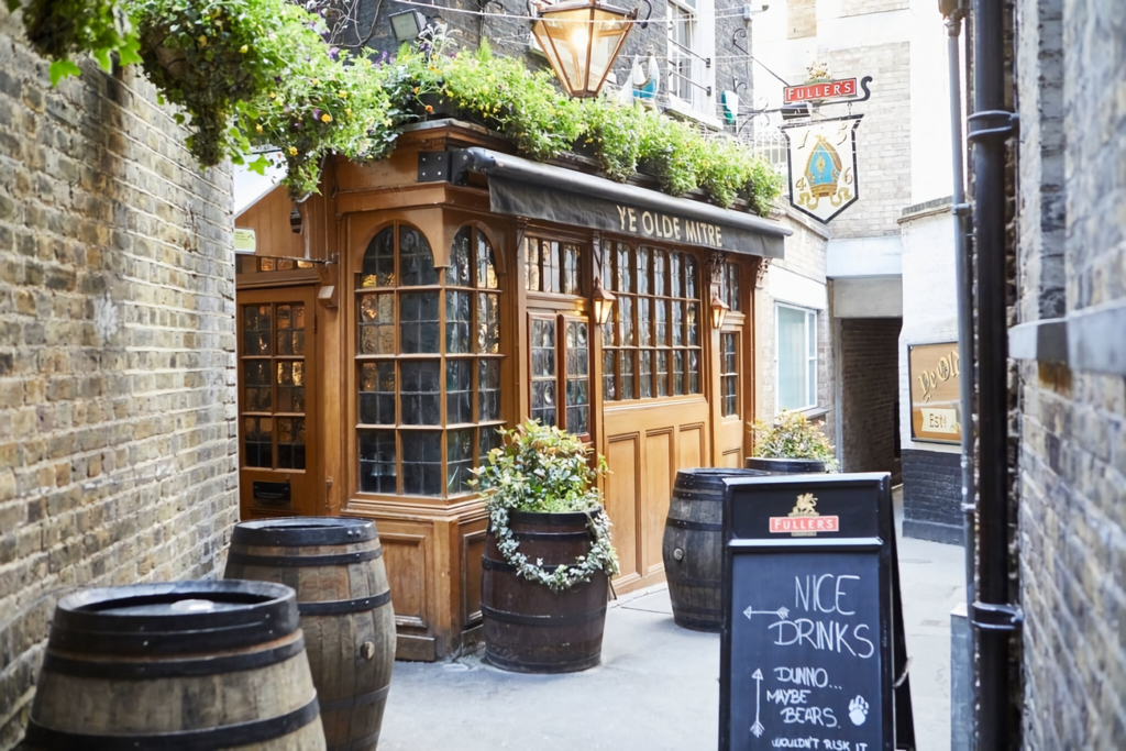 a picture of one of London's oldest pubs, Ye Olde Mitre, adorned with greenery and with a sign outside welcoming visitors in for 'nice drinks'